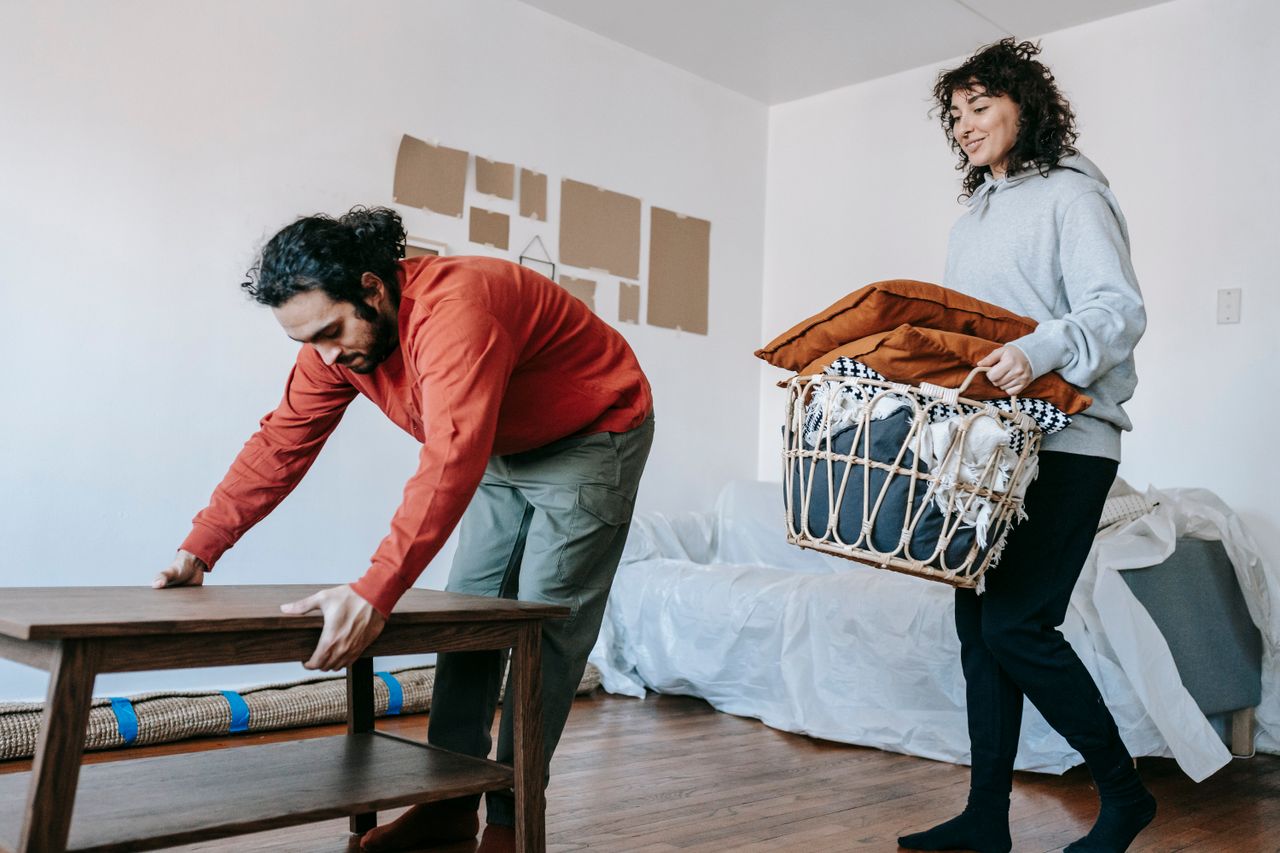 A couple organizing furniture and packing in a modern apartment for relocation.